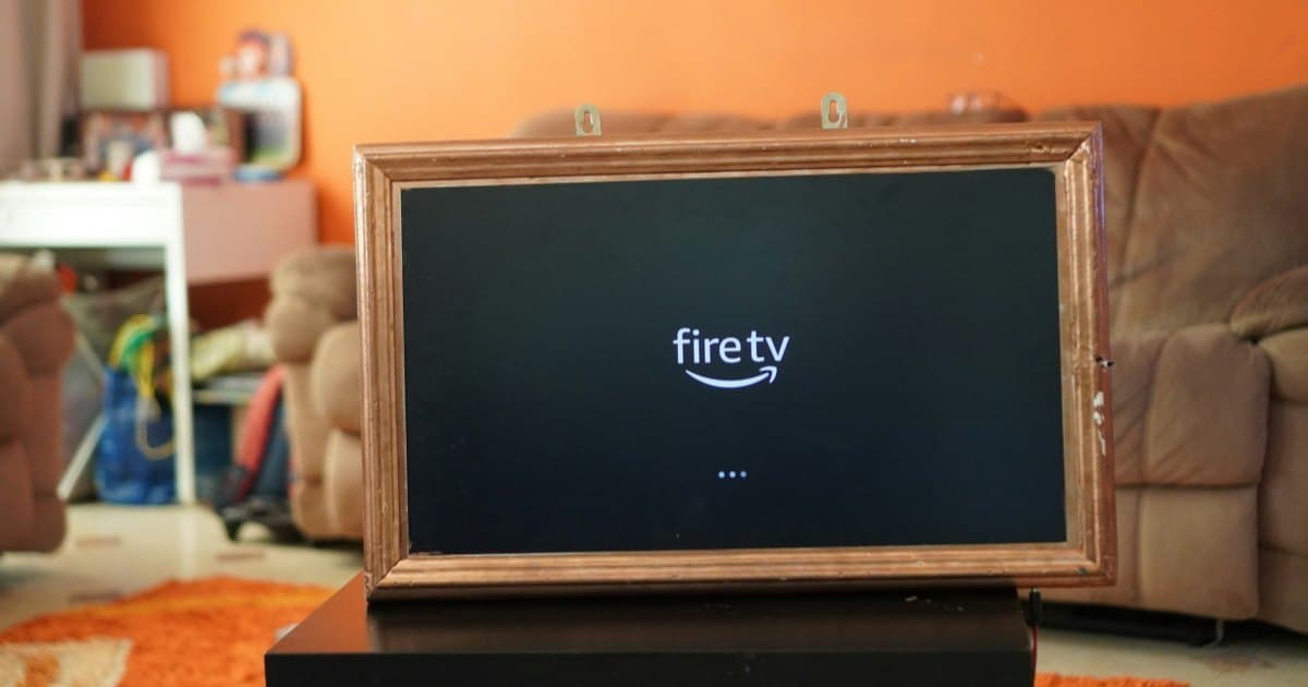 Television in a living room displaying the Fire TV start-up screen while the device loads